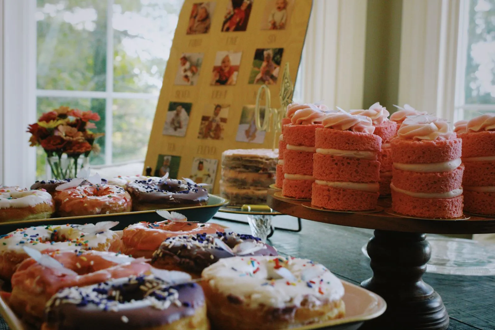 A colorful selection of donuts and layered cakes beautifully arranged for a festive celebration indoors.